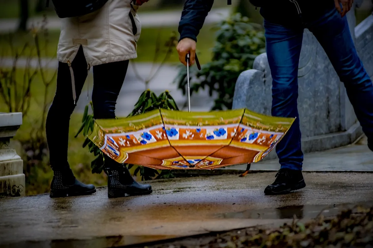 Two people carrying an ornate umbrella upside down